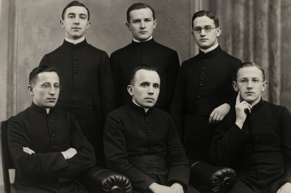 Grupa sześciu młodych polskich kleryków i księży w sutannach, pozująca do zrekonstruowanej fotografii z czasów studiów we Wrocławiu. W środku centralnie Józef Gawlina, u góry w środku ks. Jan Jarząbek.
