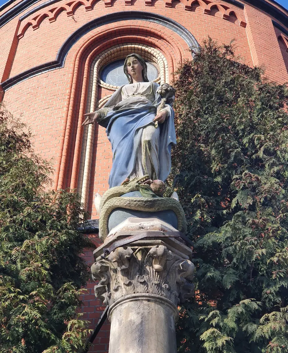 Zbliżenie na detal figury Matki Boskiej i kapitel zabytkowej kolumny w Szombierkach